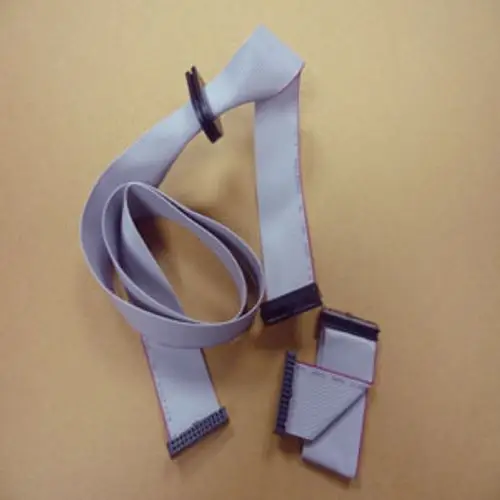 Flachbandkabel mit mehreren Anschlusssteckern, in grauer Farbe, auf einem beige Hintergrund. Das Kabel wird häufig in Geräten von Remeha verwendet.